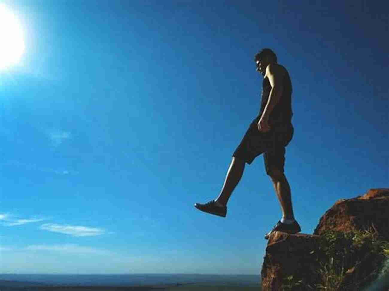 Person Standing On A Cliff, Representing Stepping Out Of Comfort Zone Beyond Gliding Distance: Stepping Out Of Your Comfort Zone